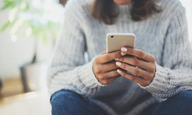 Woman in sweater looking at phone screen