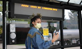 Woman looking at phone at bus stop